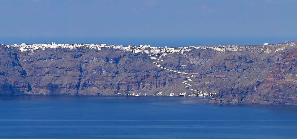 Manolas on Thirassia's caldera rim, with the stair path to the sea